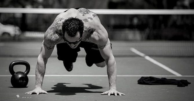 Man performing conditioning exercises outdoors, showcasing strength and endurance, essential for overall fitness.