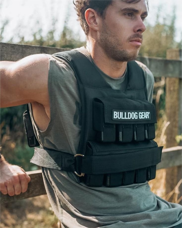 Man wearing a weighted vest for calisthenics transformation exercises, highlighting the use of added weight for progression.