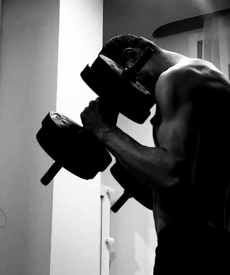 A person lifting dumbbells, illustrating the concept of active rest and recovery in a fitness routine, featured in the article 'Active Rest Day: How to Recover and Stay Active.'