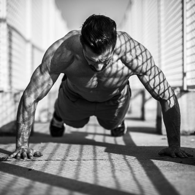 Man performing a pushup outdoors with proper form and focus, emphasizing strength and control for the perfect pushup, perfect push-up