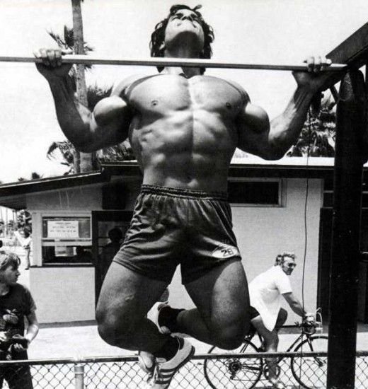 Man performing pull-ups outdoors, showcasing intense effort and the concept of training to failure in fitness.